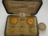a box with six gold rings in it and a coin next to it