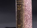 an old book sitting on top of a table next to a black background