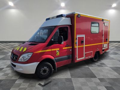 une ambulance rouge garée sur un sol à damier