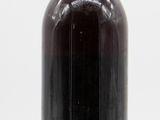 an image of a bottle of syrup sitting on a white surface