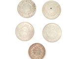 four different types of silver coins on a white surface