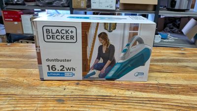 une boîte contenant un aspirateur Dustbuster de la marque Black & Decker posée sur une table