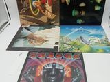 un lot de quatre disques vinyles posés sur une table blanche