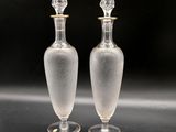 two clear glass vases sitting on top of a black table