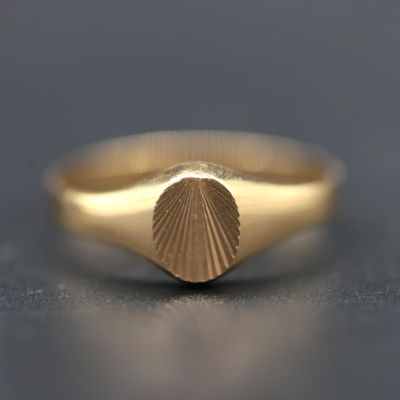 a close up of a gold ring with a shell in the middle
