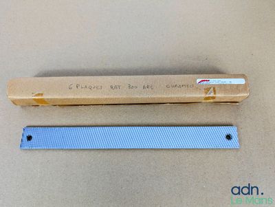 une boîte de brosses à dents posée sur une table à côté d'une règle