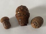 trois petits objets en bois posés sur une surface blanche