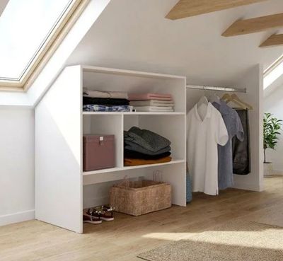 une armoire contenant des vêtements et sur laquelle sont posés des vêtements, dans une pièce
