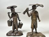 paire de figurines en bronze représentant un homme et une femme portant des seaux sur la tête