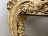 an ornately carved console table with a mirror on top of it