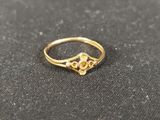 gros plan d'une bague en or sur une surface noire