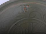 a close up of a green bowl with red spots on it