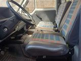 a seat in the back of a truck with a plaid seat cover