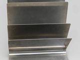 a close up of a metal book holder on a white surface