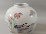 a white vase with a picture of a woman and a bird on it