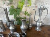 many different types of pewware sitting on a wooden table