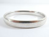 gros plan d'une bague en argent sur une surface blanche