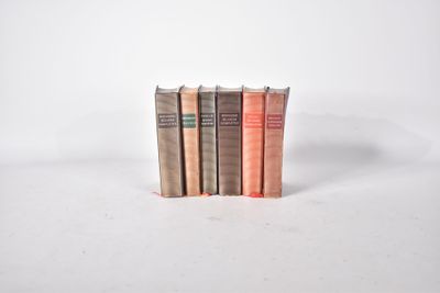 trois livres sont empilés sur une surface blanche