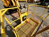 a yellow work platform sitting in the middle of a parking lot