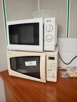deux micro-ondes posés sur un plan de travail en bois