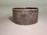 a silver ring with a design on it on a table
