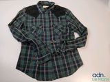 un gros plan d'une chemise à carreaux posée sur une surface blanche