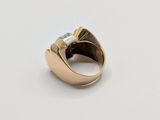 a close up of a gold and diamond ring on a white surface