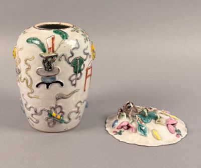 a white vase with a cat on it next to a small bowl