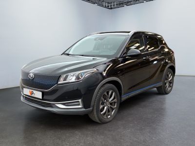 Un SUV noir est garé dans une grande pièce au sol noir.
