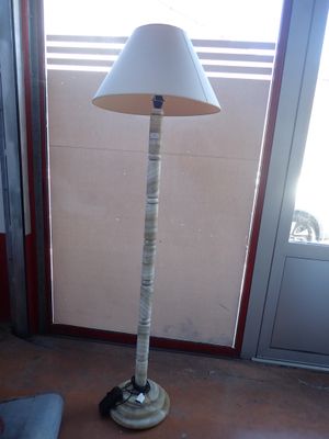 a lamp that is sitting on the floor in front of a window