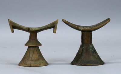 paire de cornes d'éléphant en laiton ancien posées sur des socles, sur fond blanc