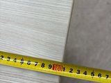 someone is measuring the length of a piece of wood with a tape measure