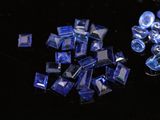 a pile of blue glass pieces on a black surface