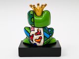 the frog is wearing a crown on its head and sitting on a black stand