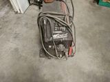 an image of a welding machine in a garage next to a stack of boxes