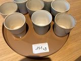six tasses de café posées sur une assiette, sur une table