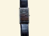 a black watch with a brown face on a black strap