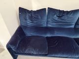 a blue couch with two pillows on it in a room