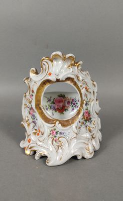 un gros plan d'un petit vase blanc orné de fleurs