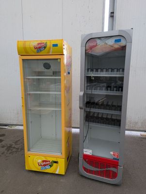 two refrigerators that are next to each other on the ground
