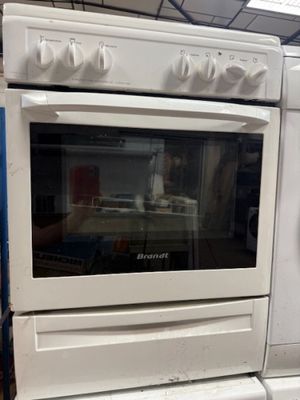 un four blanc posé sur une cuisinière blanche