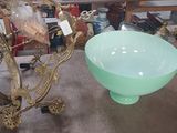 a green glass bowl sitting on a table next to a mirror