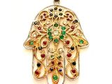 une photo d'un pendentif en forme de main de Hamsa en or, orné de pierres multicolores