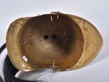 a gold helmet with a long black hair in it