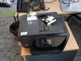 une imprimante posée sur un bureau à côté d'un téléphone portable
