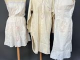 three dresses on mannequins on display against a gray background