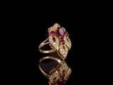 une bague en or sertie d'un rubis et de diamants sur un fond noir