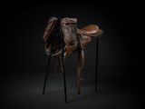 une selle de cheval marron posée sur un support en bois