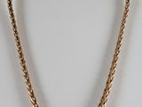 un collier à chaîne en or au motif torsadé sur un mannequin blanc