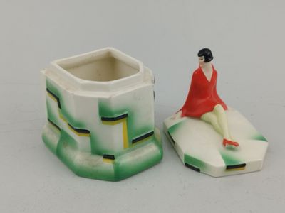 une figurine représentant une femme assise sur un vase